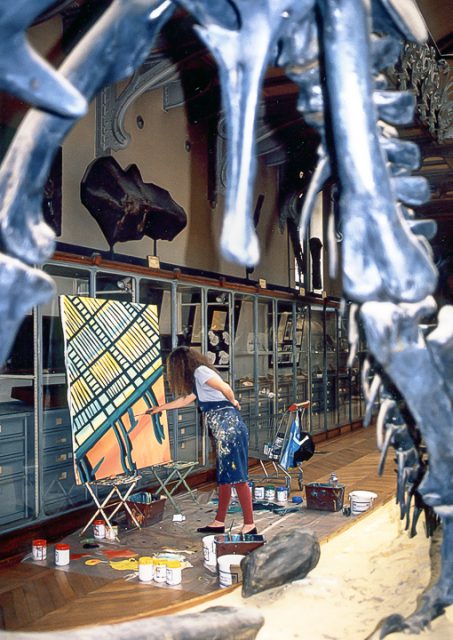 Michelle Auboiron peint le dinosaure dans la grande Galerie de Paléontologie du Muséum d'hisoire Naturelle du Jardin des Plantes de Paris